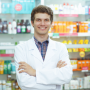 male pharmacist smiling in a pharmacy