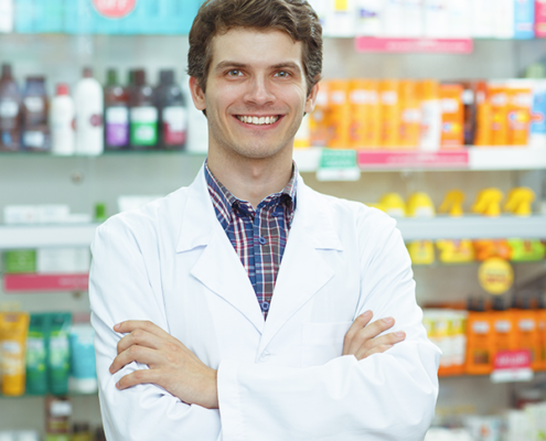 male pharmacist smiling in a pharmacy