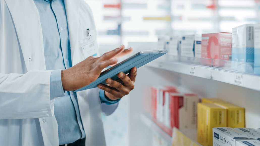 pharmacist scrolling on a tablet computer managing programs