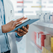 pharmacist scrolling on a tablet computer managing programs