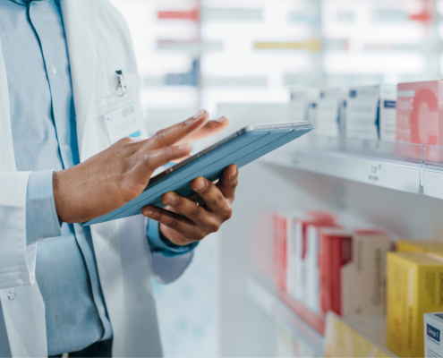 pharmacist scrolling on a tablet computer managing programs