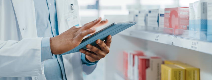 pharmacist scrolling on a tablet computer managing programs